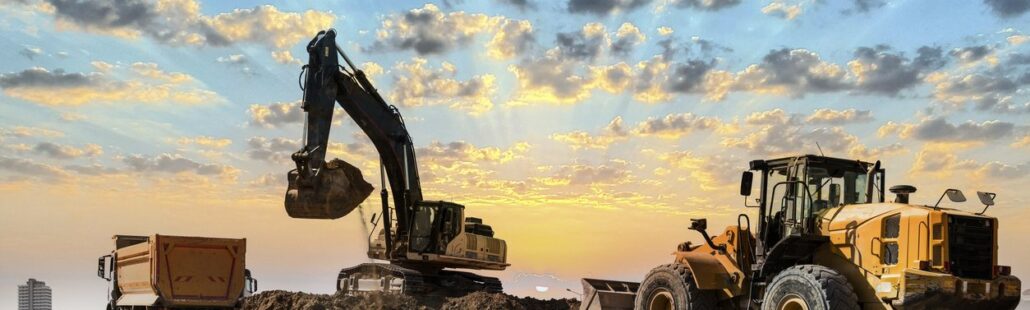 Excavators working on construction site at sunset